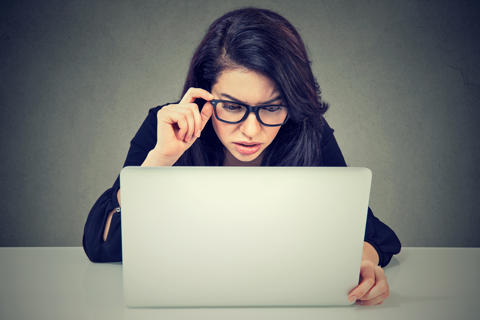 Woman looking confused at computer screen